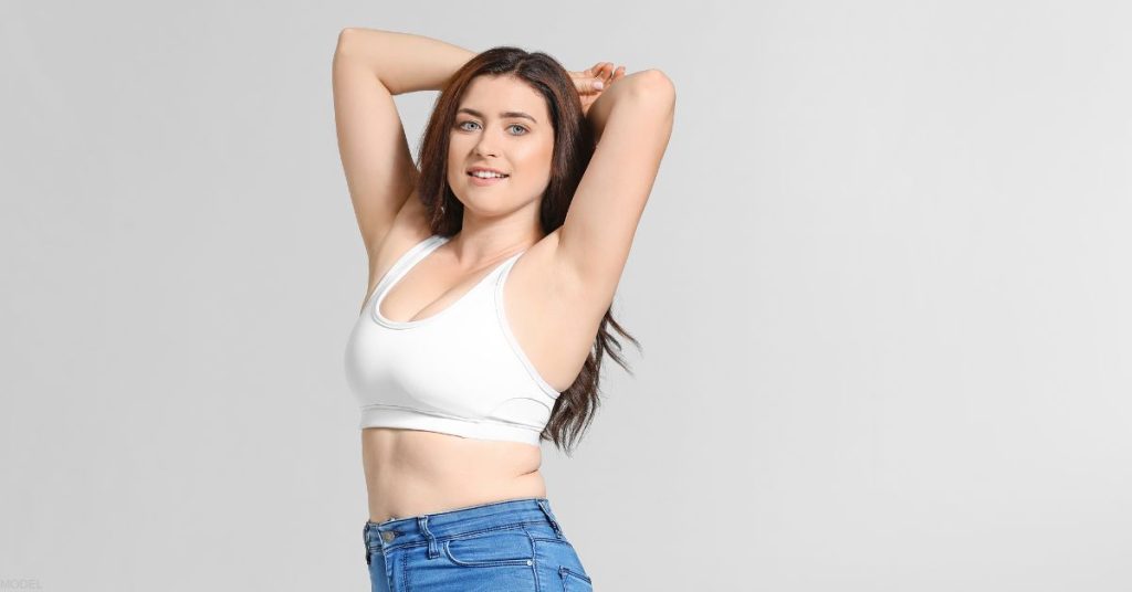 Body positive woman posing with her hands over her head (model)