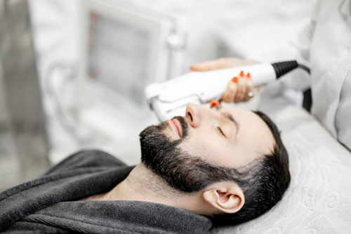 Dr. Jeffrey Roth performing a facial procedure on a male patient, highlighting the precision and expertise involved.